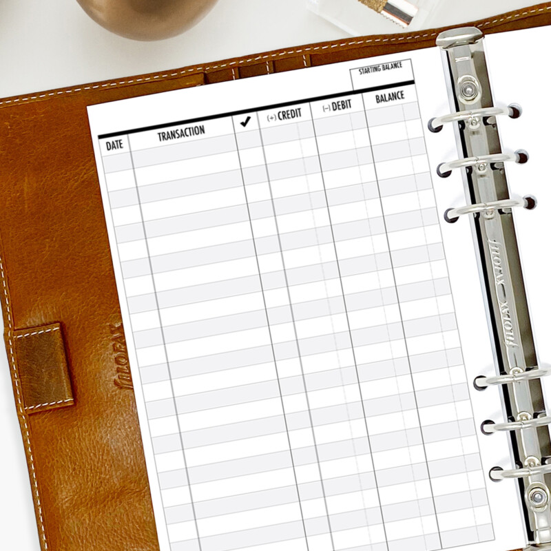 Vertical money tracker planner insert shown in ring-bound planner with pen