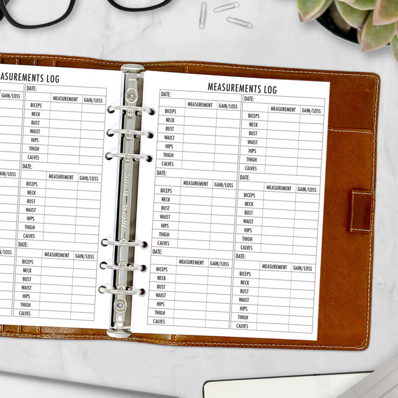 Planner insert with body measurement chart inside ring-bound planner on desk