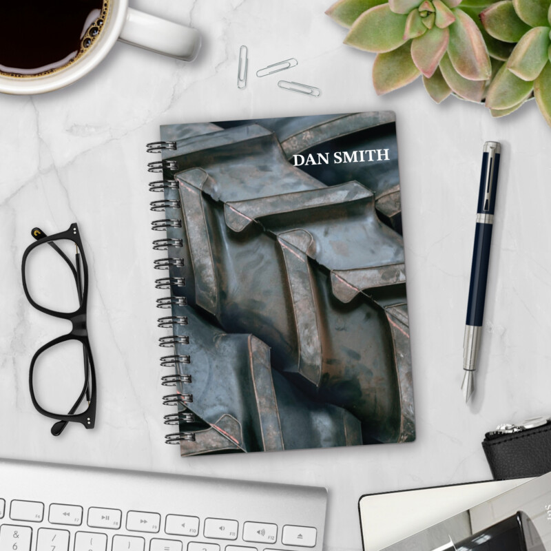 Personalized hardcover notebook in Off-Road Agenda design with close-up tractor or off-road tire tread pattern styled on marble desk with coffee and pen