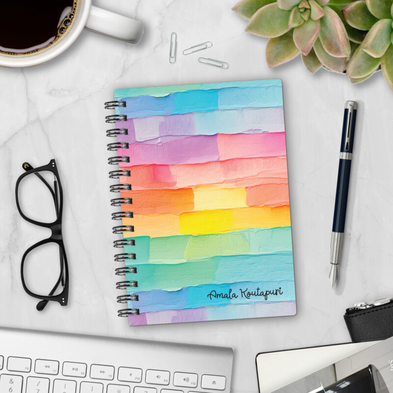 Personalized hardcover notebook in Palette Cake design with thick rainbow paint stripes in pastel and bright colors styled on marble desk with coffee