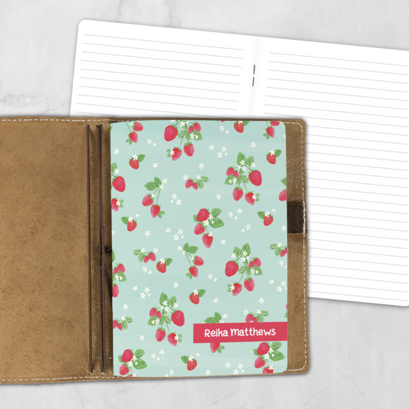 A5 Berry Overbooked lifestyle personalized traveler's notebook refill showing the cover design inside a leather traveler's notebook cover, with lined refill pages visible behind.