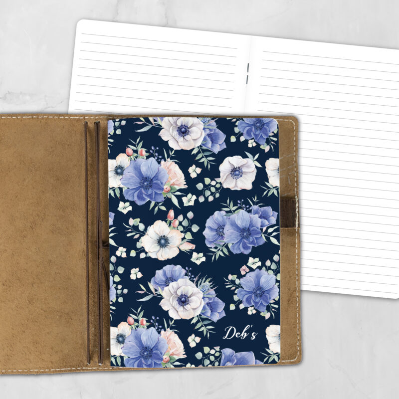 A5 Blooming Mystery lifestyle personalized traveler's notebook refill showing the cover design inside a leather traveler's notebook cover, with lined refill pages visible behind.