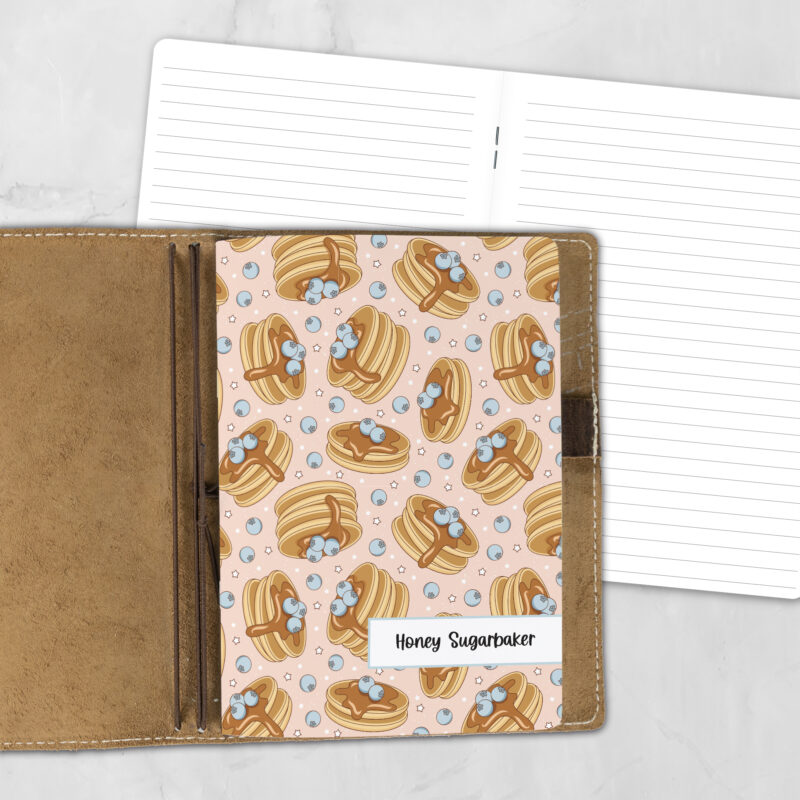 A5 Blueberry Pancakes personalized traveler's notebook refill showing the cover design inside a leather traveler's notebook cover, with lined refill pages visible behind.