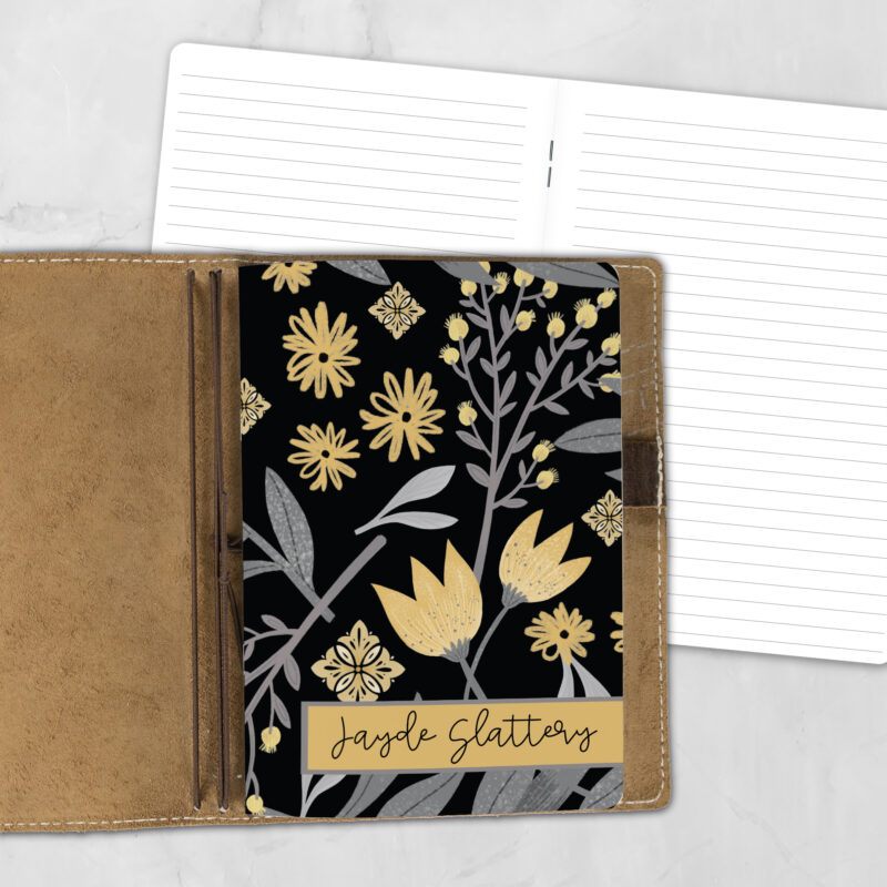 A5 Citrus Noir personalized traveler's notebook refill showing the cover design inside a leather traveler's notebook cover, with lined refill pages visible behind.