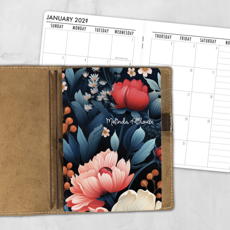 A5 Dark Jewels lifestyle personalized traveler's notebook refill showing the cover design inside a leather traveler's notebook cover, with a monthly calendar spread visible behind.