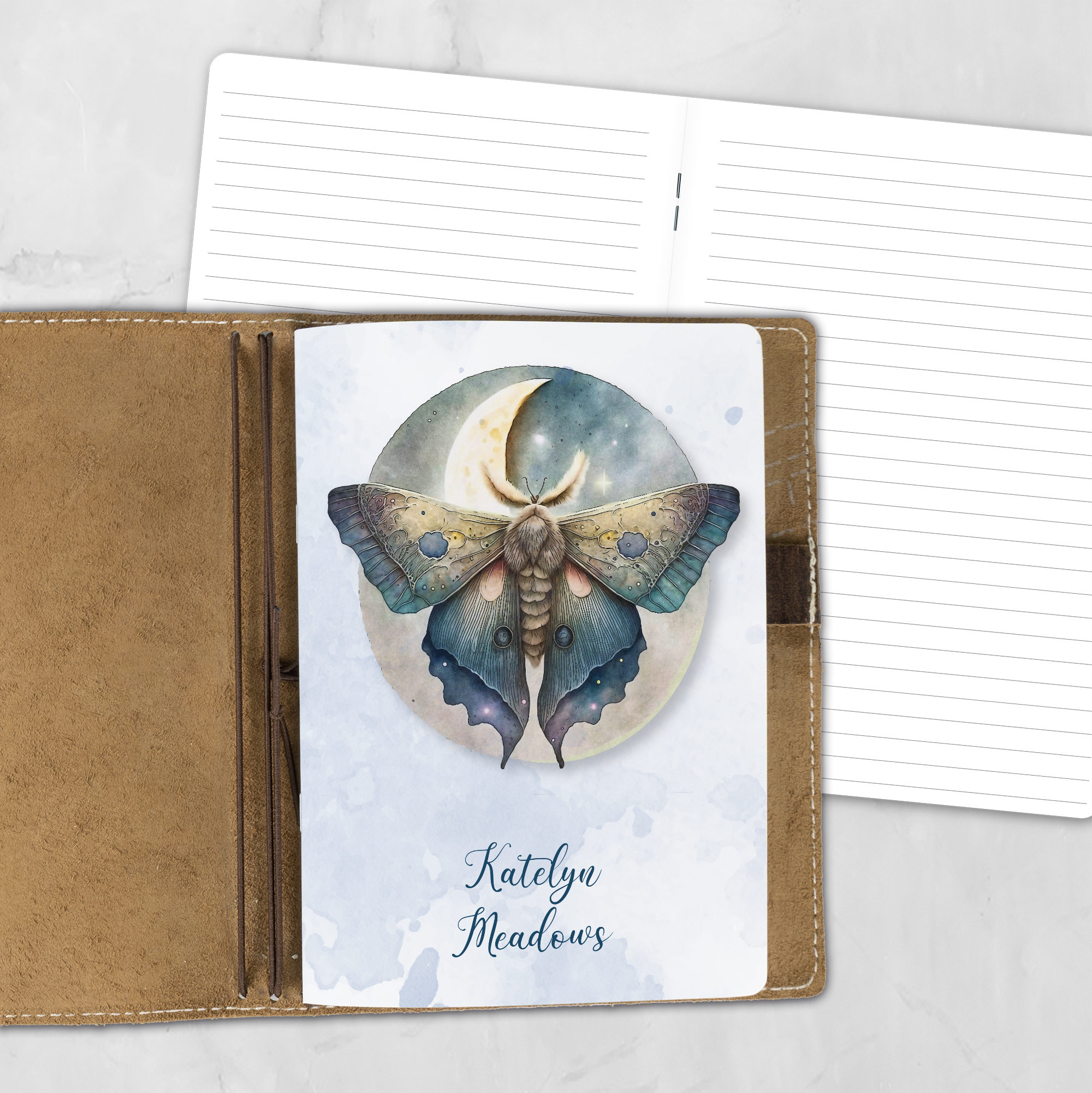 A5 Golden Wings personalized traveler's notebook refill showing the cover design inside a leather traveler's notebook cover, with lined refill pages visible behind.