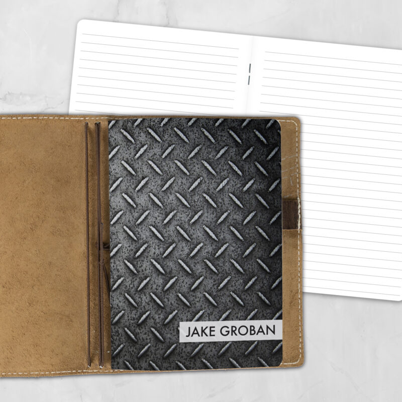 A5 Industrial Strength personalized traveler's notebook refill showing the cover design inside a leather traveler's notebook cover, with lined refill pages visible behind.