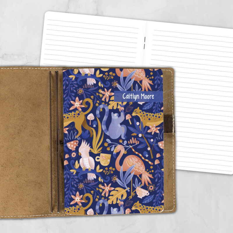 A5 Jungle Love lifestyle personalized traveler's notebook refill showing the cover design inside a leather traveler's notebook cover, with lined refill pages visible behind.
