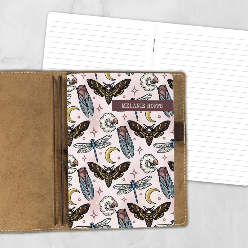 A5 Moonlit Macabre lifestyle personalized traveler's notebook refill showing the cover design inside a leather traveler's notebook cover, with lined refill pages visible behind.