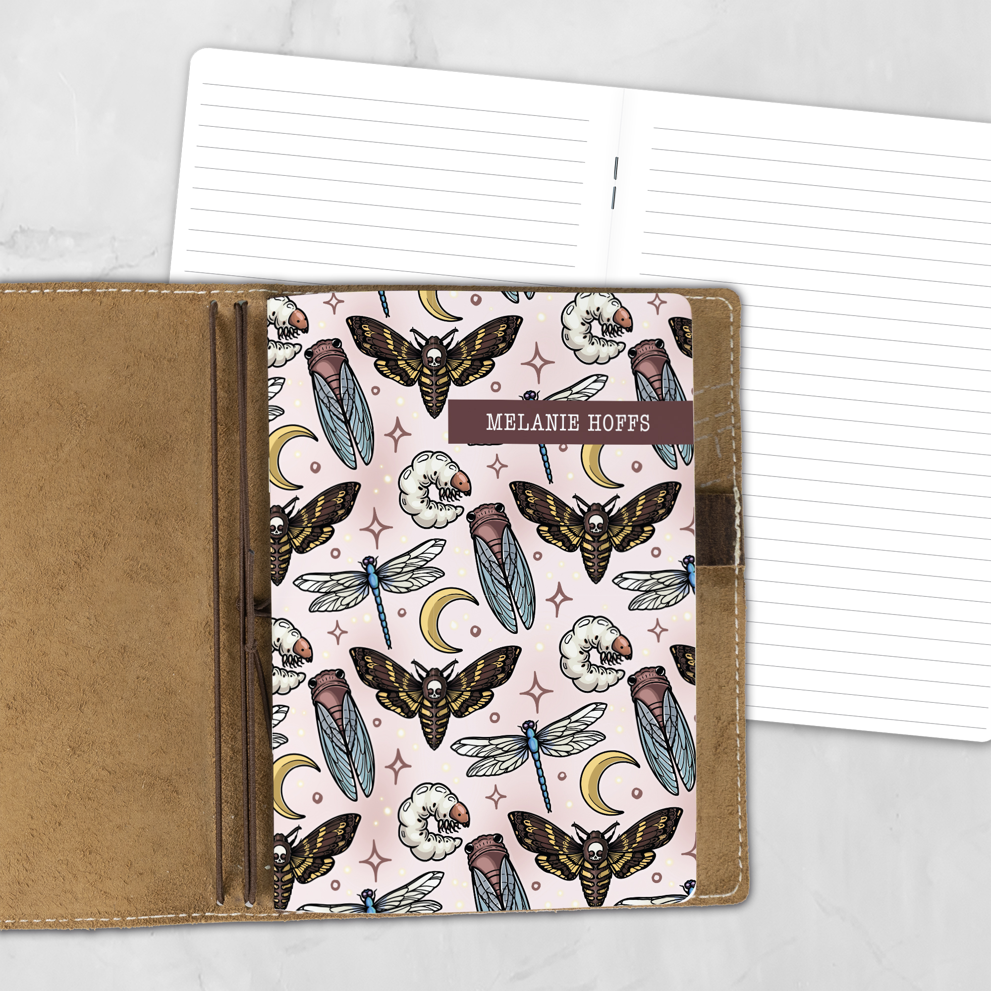 A5 Moonlit Macabre lifestyle personalized traveler's notebook refill showing the cover design inside a leather traveler's notebook cover, with lined refill pages visible behind.