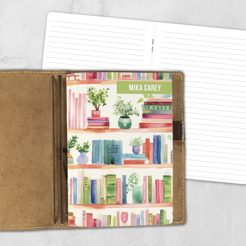 A5 Shelf Control personalized traveler's notebook refill showing the cover design inside a leather traveler's notebook cover, with lined refill pages visible behind.