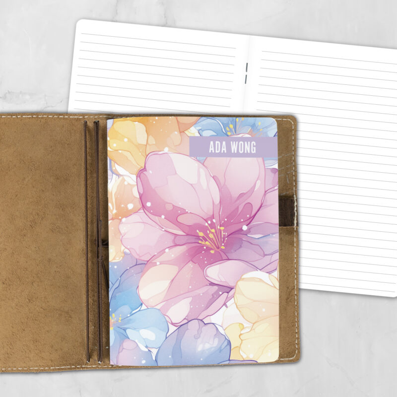 A5 Spring Petals personalized traveler's notebook refill showing the cover design inside a leather traveler's notebook cover, with lined refill pages visible behind.
