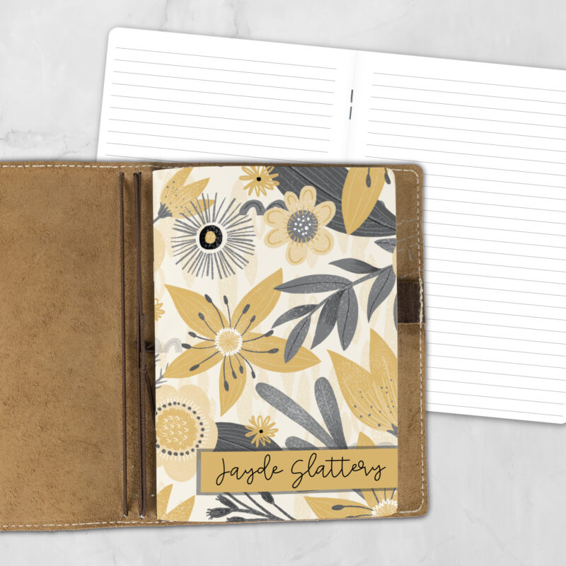 A5 Sunglow personalized traveler's notebook refill showing the cover design inside a leather traveler's notebook cover, with lined refill pages visible behind.