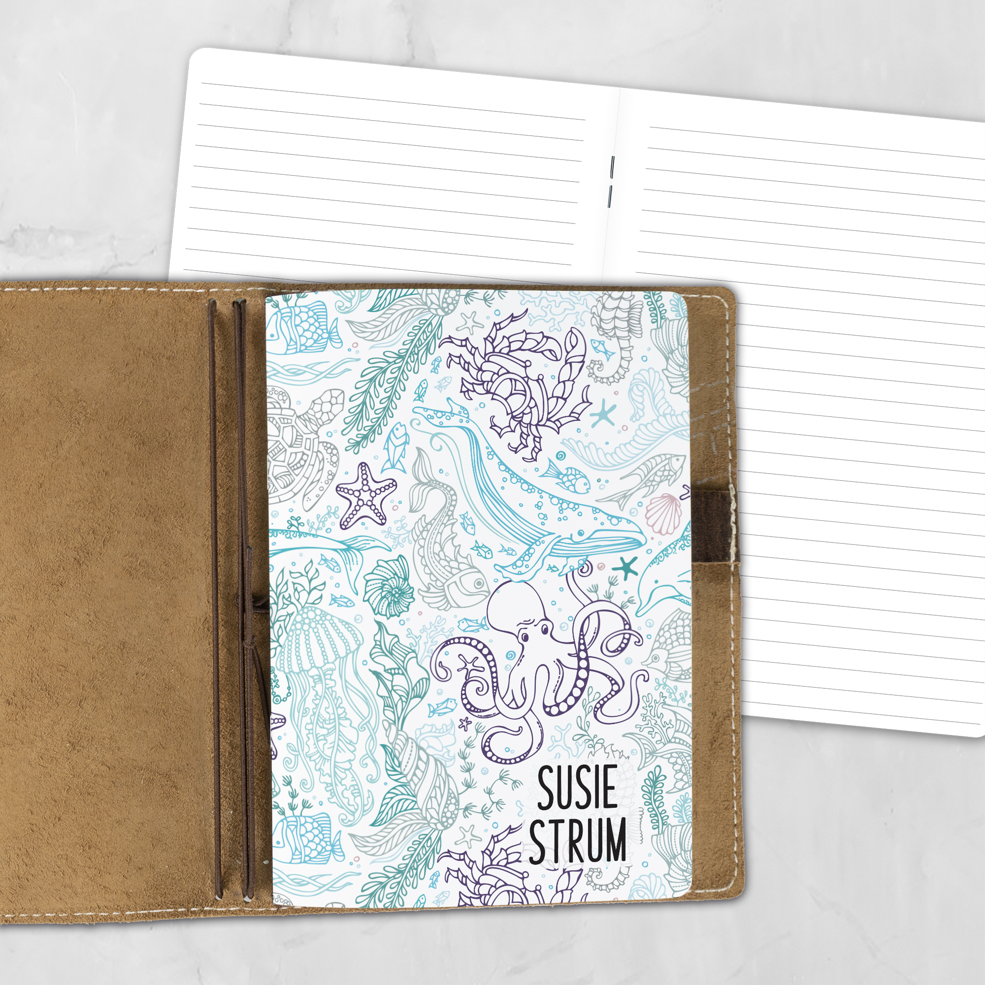 A5 Underwater Seaglass personalized traveler's notebook refill showing the cover design inside a leather traveler's notebook cover, with lined refill pages visible behind.