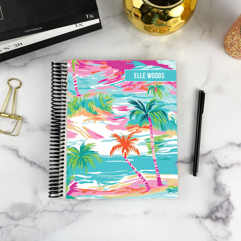 7x9 spiral bound planner in the Aquarelle Sky cover design on a marble surface with styling accessories.