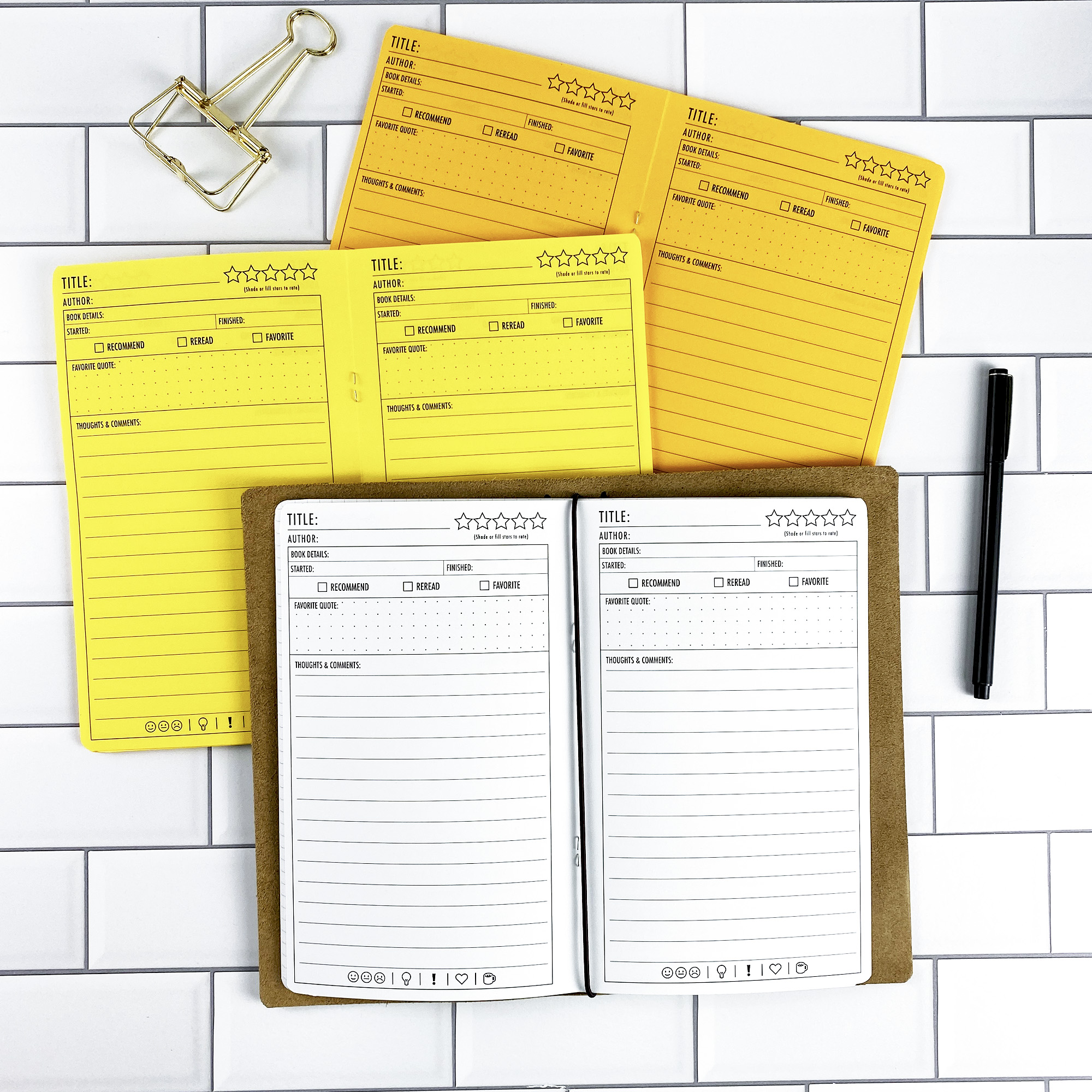 Book Review traveler's notebook refill by CityGirl Planners, showing review pages with fields for title, author, star rating, and reading notes. Three booklets in yellow paper shades alongside a white paper version in a traveler's notebook cover.