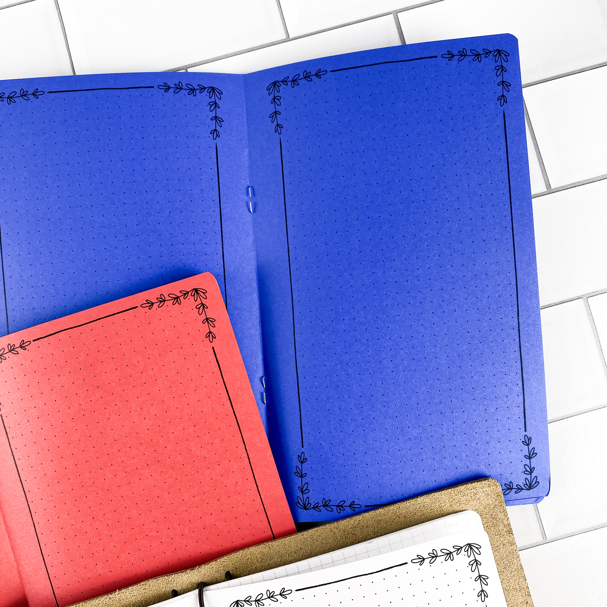 Detail view of the Botanical Notes traveler's notebook refill showing decorative note pages with botanical floral border design, displayed with multiple paper color options.