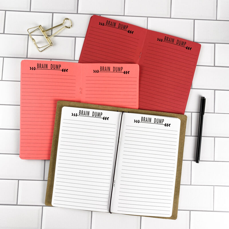 Brain Dump traveler's notebook refill by CityGirl Planners, showing lined brain dump pages for free-form note taking. Three booklets displayed in different paper color options inside a traveler's notebook cover.