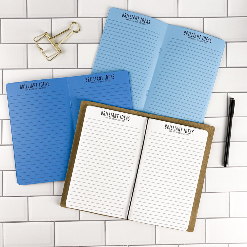 Brilliant Ideas traveler's notebook refill by CityGirl Planners, showing idea capture pages with a lined layout for brainstorming. Three booklets displayed in different paper color options inside a traveler's notebook cover.