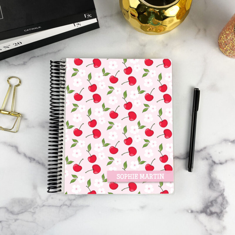7x9 spiral bound planner in the Cherry Pop cover design on a marble surface with styling accessories.