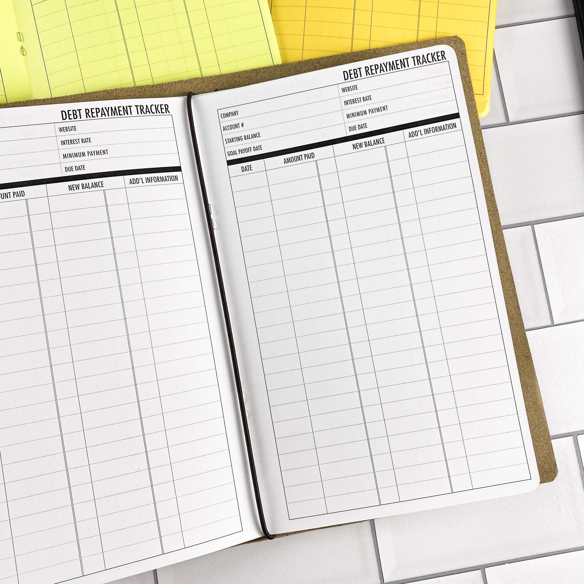 Close-up detail of the Debt Repayment traveler's notebook refill showing the page layout and debt repayment tracker pages for managing payoff progress in colored paper.