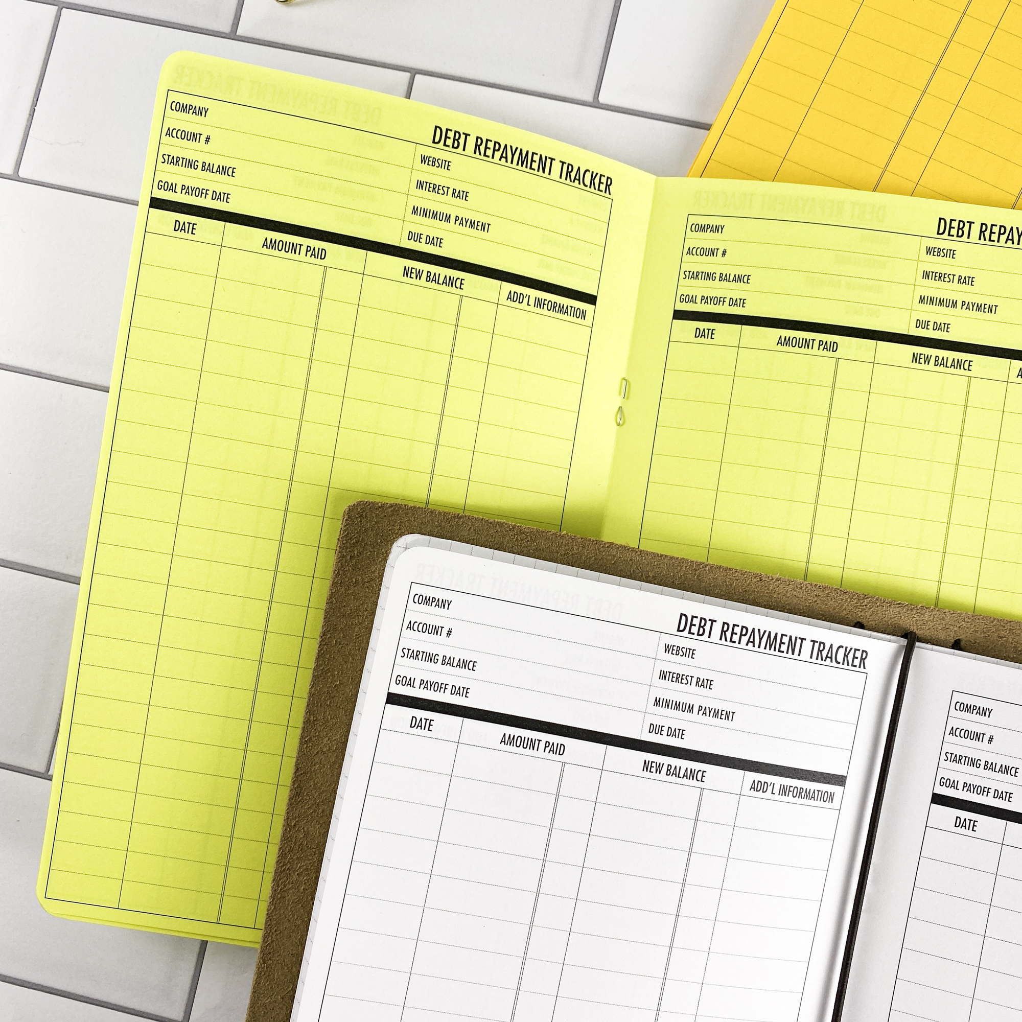 Detail view of the Debt Repayment traveler's notebook refill showing debt repayment tracker pages for managing payoff progress, displayed with multiple paper color options.