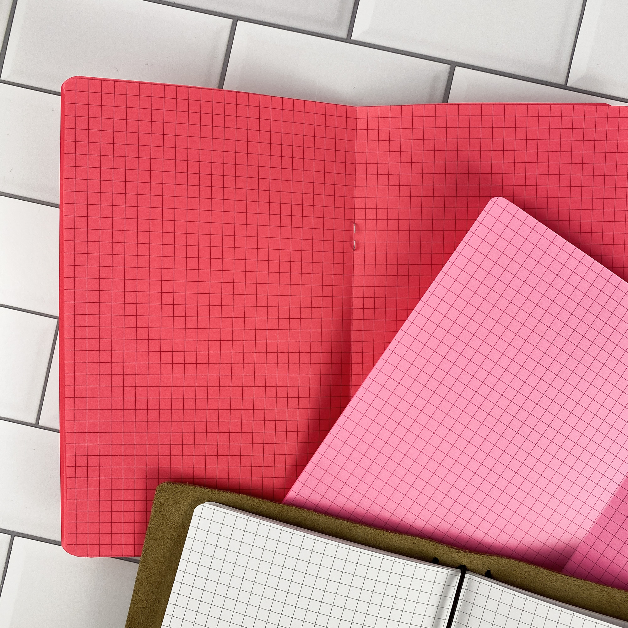 Close-up detail of the Graph Paper traveler's notebook refill showing the page layout and graph paper grid pages in colored paper.