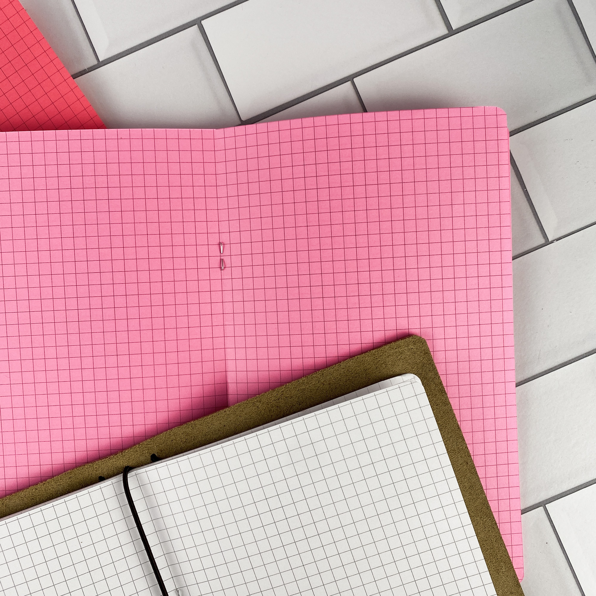 Close-up detail of the Graph Paper traveler's notebook refill showing the page layout and graph paper grid pages in colored paper.