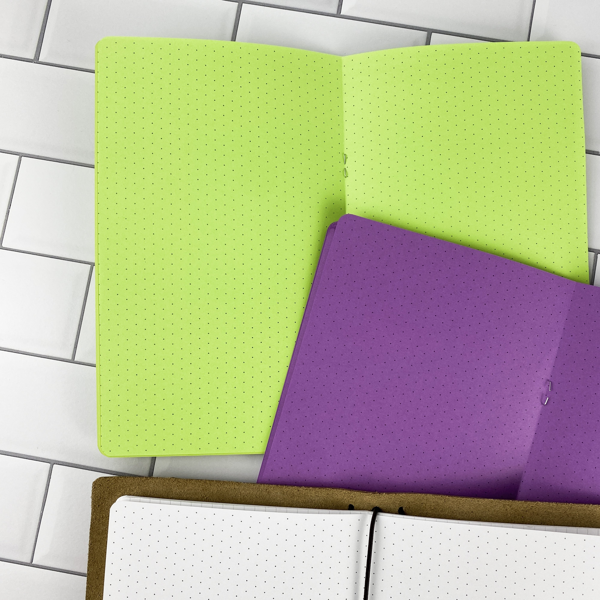 Close-up detail of the Isometric Dots traveler's notebook refill showing the page layout and isometric dot grid pages for 3D sketching and technical drawing in colored paper.