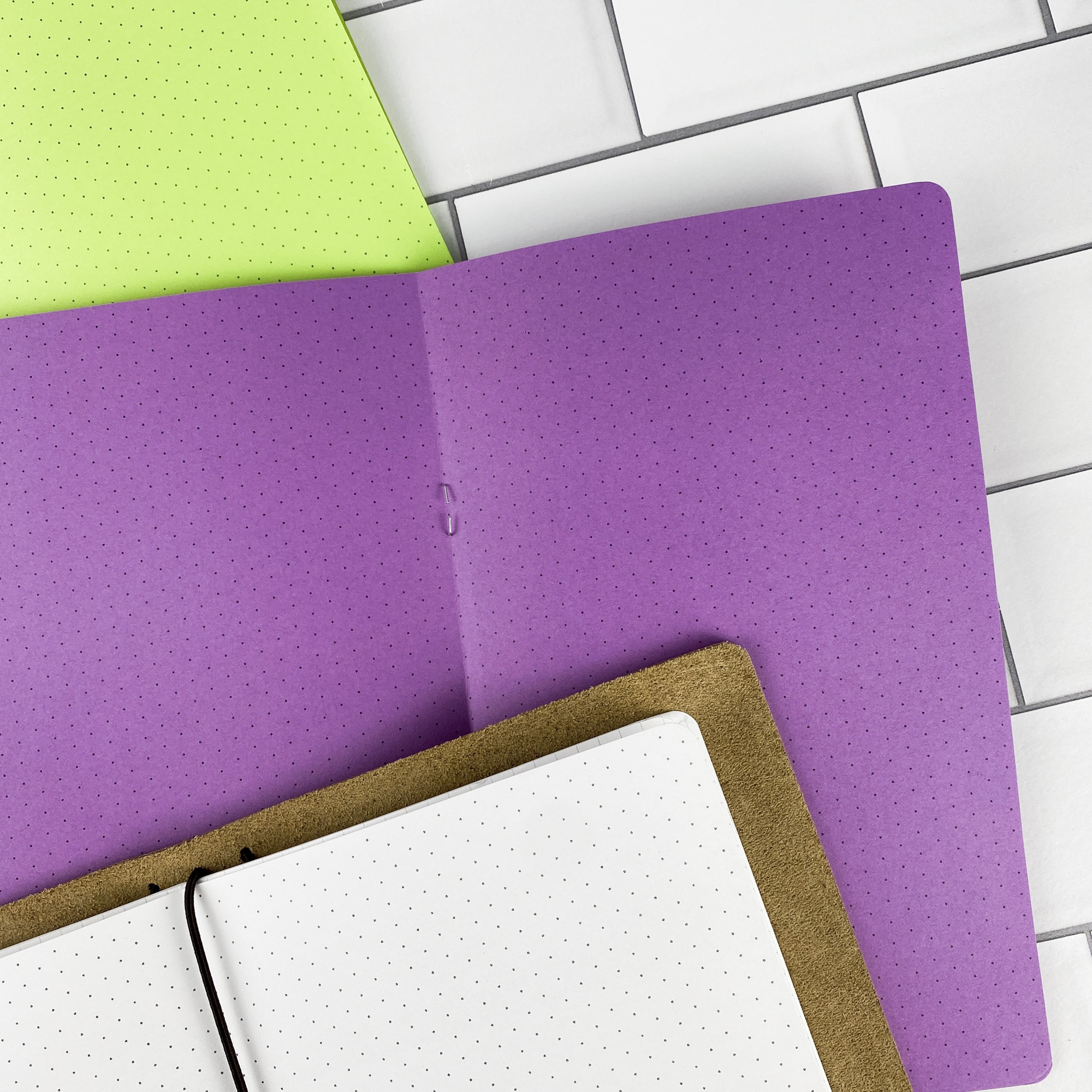 Detail view of the Isometric Dots traveler's notebook refill showing isometric dot grid pages for 3D sketching and technical drawing, displayed with multiple paper color options.