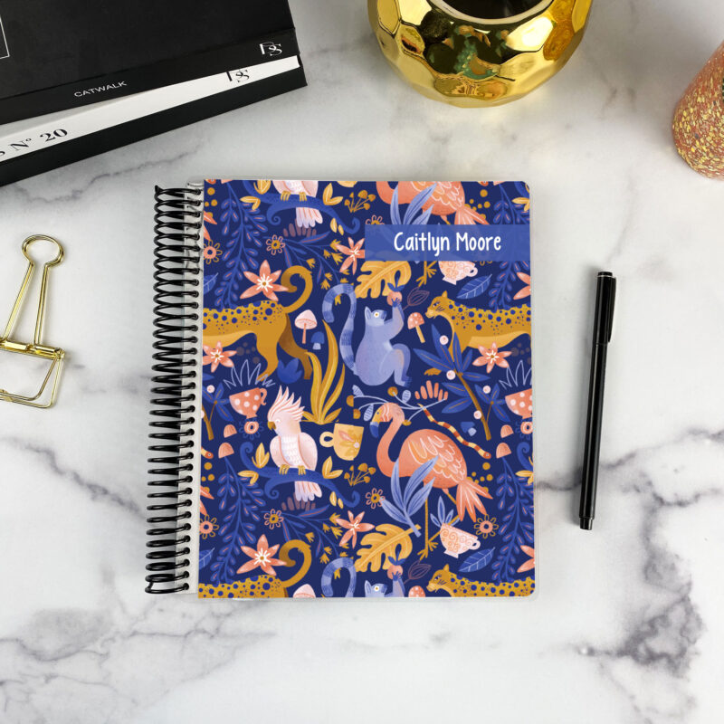 7x9 spiral bound planner in the Jungle Love cover design on a marble surface with styling accessories.