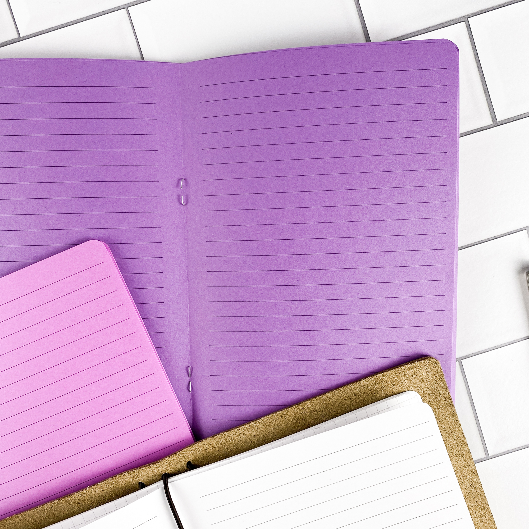 Detail view of the Lined traveler's notebook refill showing lined pages for everyday note taking, displayed with multiple paper color options.