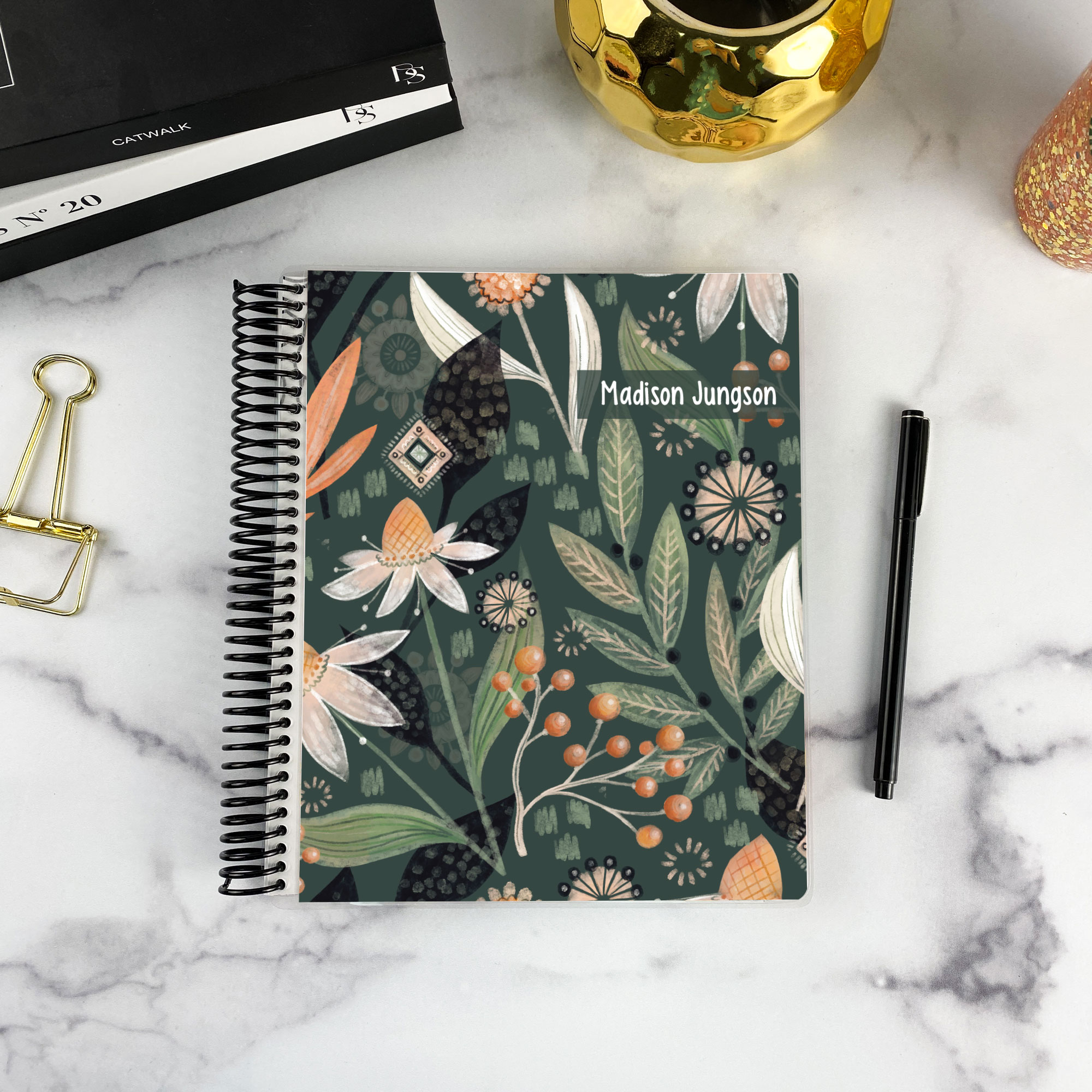 7x9 spiral bound planner in the Night Garden cover design on a marble surface with styling accessories.