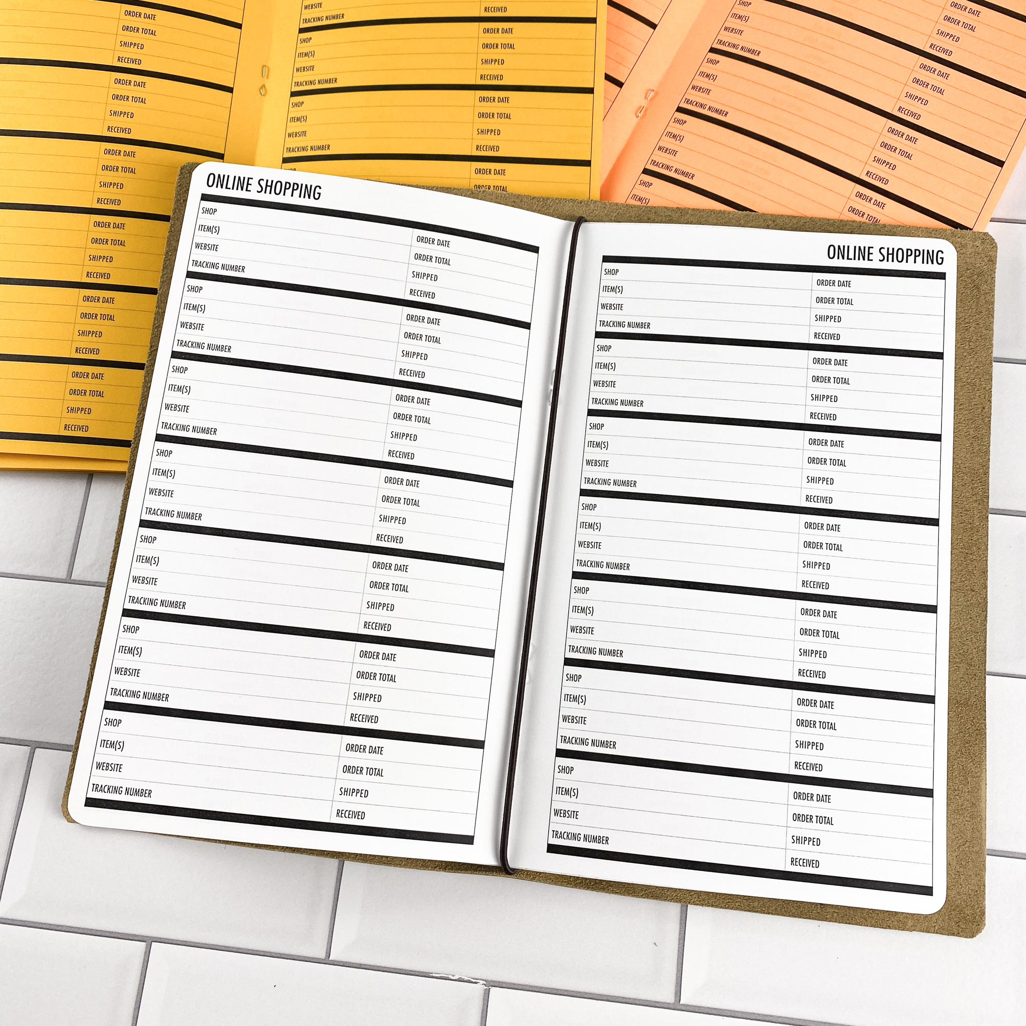 Online Shopping traveler's notebook refill opened to show the online shopping tracker pages for managing orders and deliveries in bright white paper, saddle-stitched booklet format.