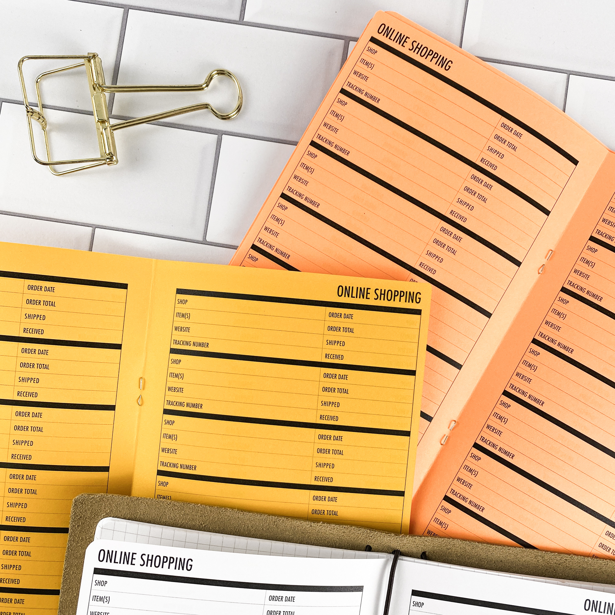 Detail view of the Online Shopping traveler's notebook refill showing online shopping tracker pages for managing orders and deliveries, displayed with multiple paper color options.