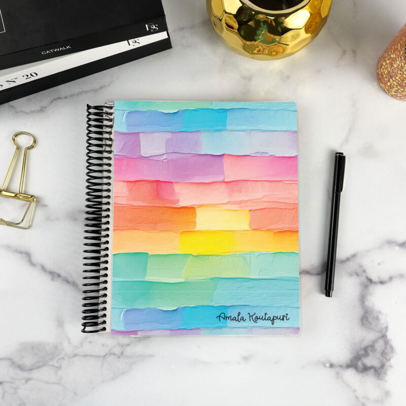 7x9 spiral bound planner in the Palette Cake cover design on a marble surface with styling accessories.