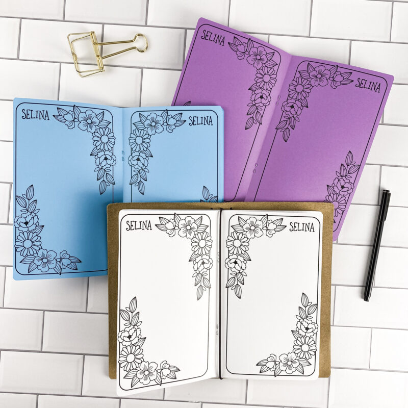 Pressed Petals traveler's notebook refill by CityGirl Planners, showing decorative pages with a pressed floral border design and personalized name. Three booklets displayed in different paper color options inside a traveler's notebook cover.