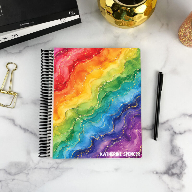7x9 spiral bound planner in the Prism cover design on a marble surface with styling accessories.
