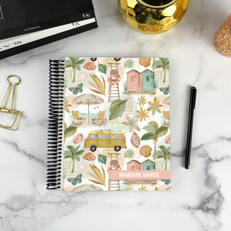 7x9 spiral bound planner in the Retro Coastline cover design on a marble surface with styling accessories.