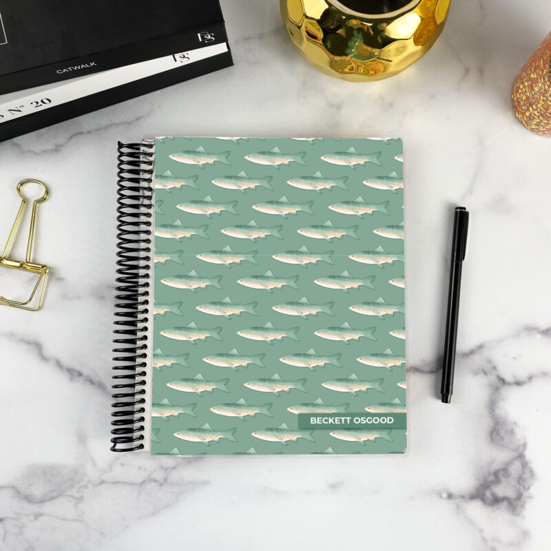 7x9 spiral bound planner in the River Run cover design on a marble surface with styling accessories.