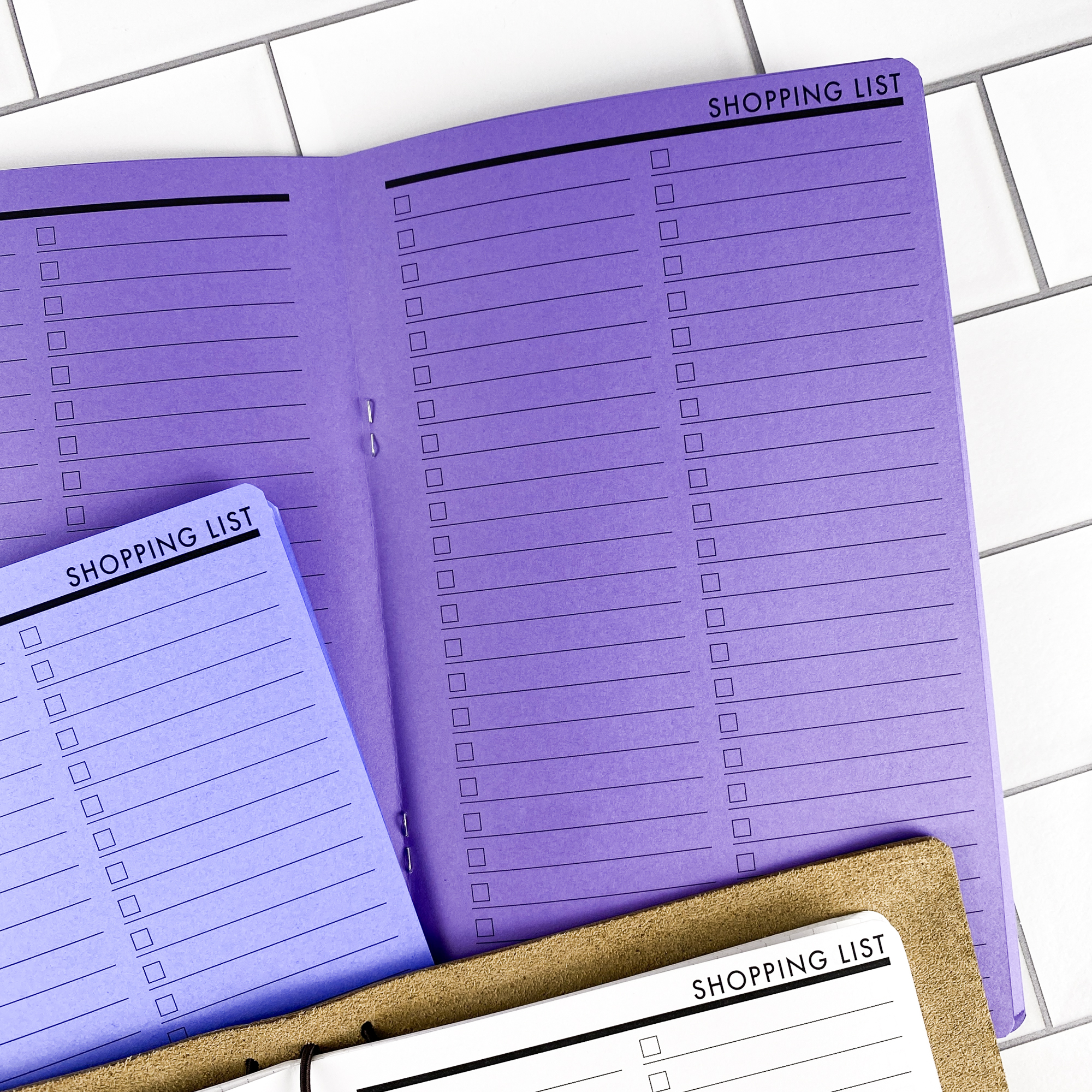 Detail view of the Shopping List traveler's notebook refill showing shopping list pages for organizing grocery and errand lists, displayed with multiple paper color options.