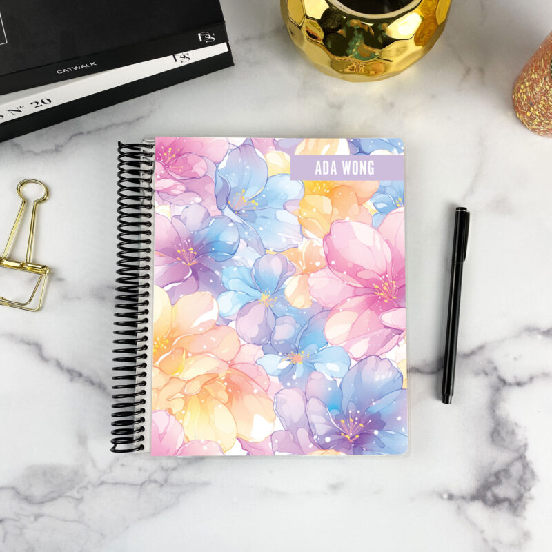 7x9 spiral bound planner in the Spring Petal cover design on a marble surface with styling accessories.