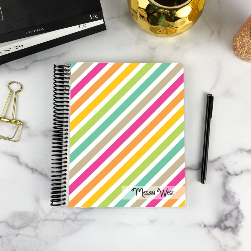 7x9 spiral bound planner in the Stripe hype cover design on a marble surface with styling accessories.