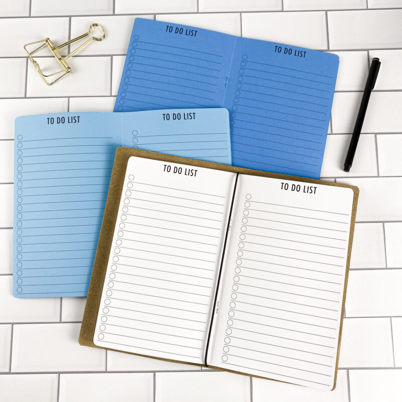 To Do traveler's notebook refill by CityGirl Planners, showing to-do list pages with checkbox layout for daily task management. Three booklets displayed in different paper color options inside a traveler's notebook cover.