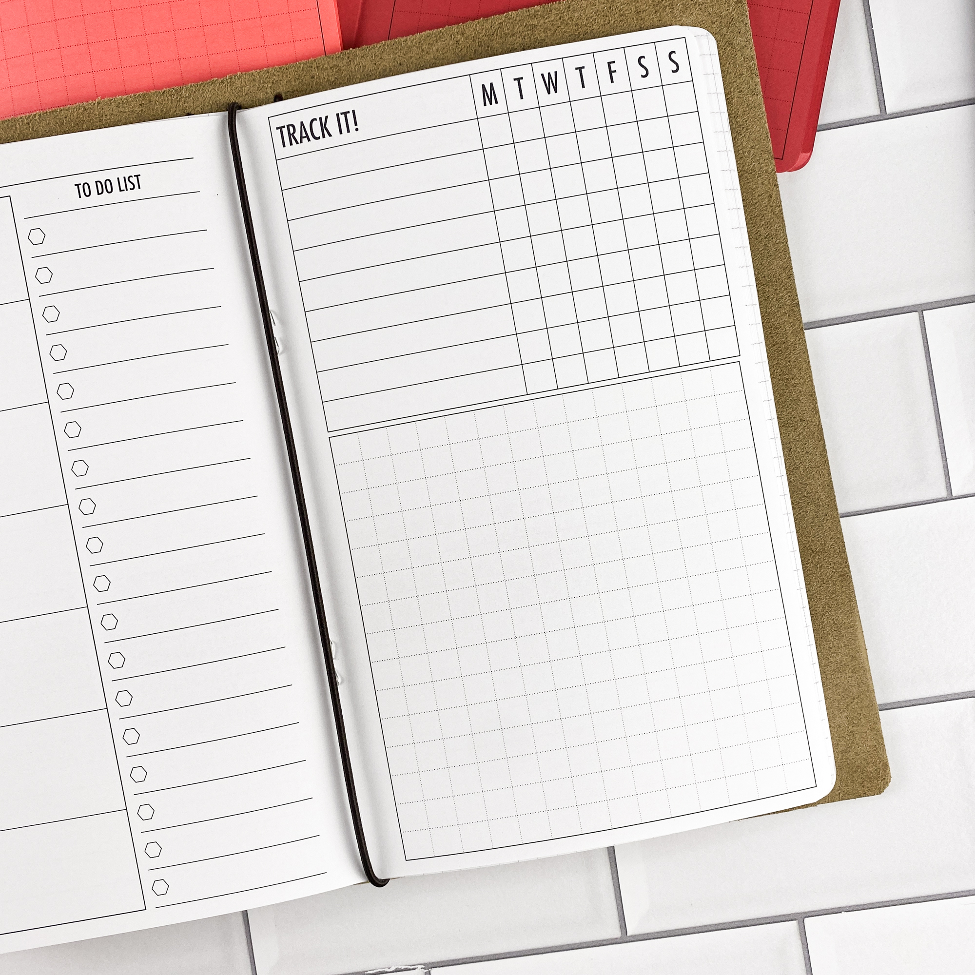 Close-up detail of the Week at a Glance traveler's notebook refill showing the page layout and weekly planner spread showing a full week at a glance in colored paper.