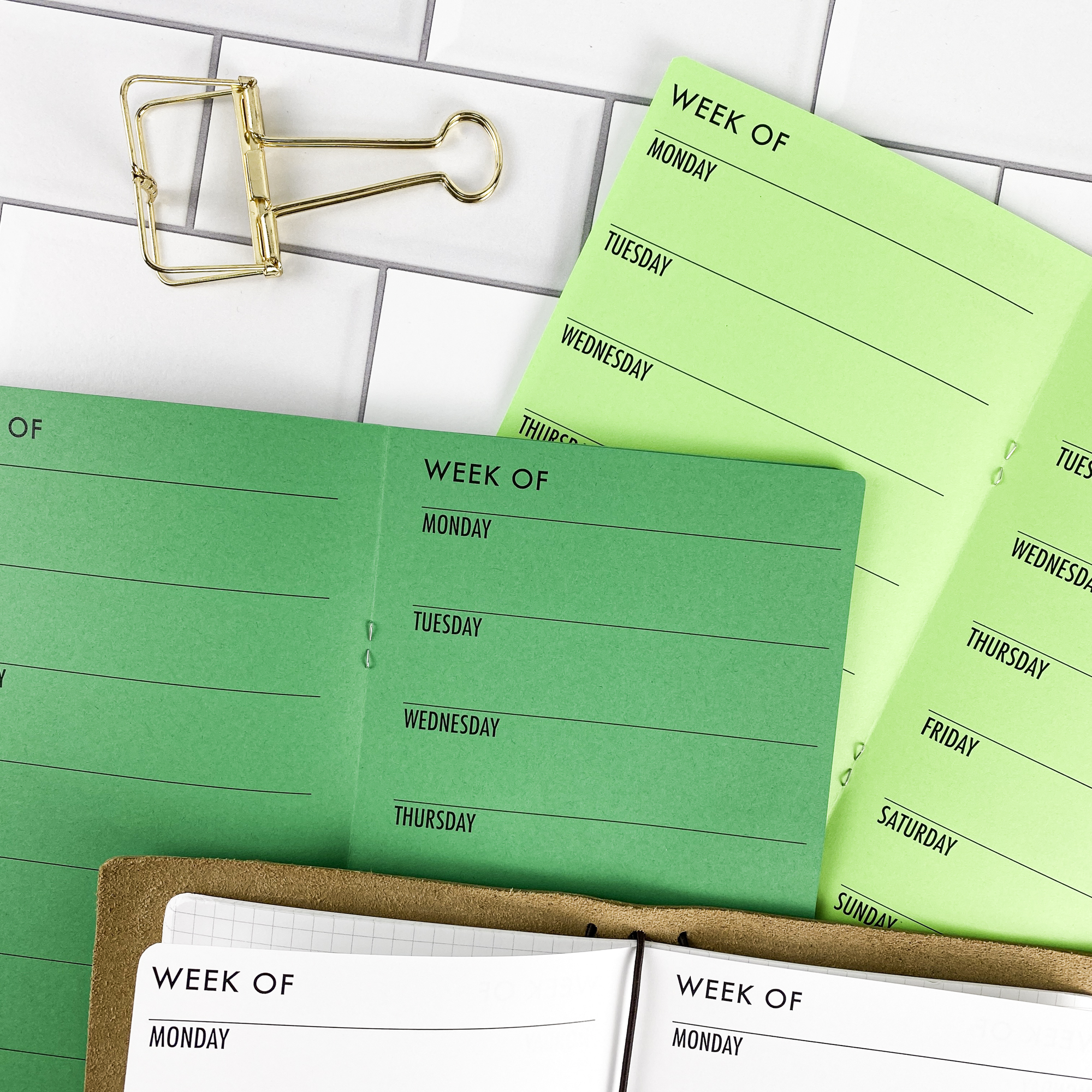 Detail view of the Week on 1 Page Horizontal traveler's notebook refill showing horizontal weekly planner layout fitting a full week on one page, displayed with multiple paper color options.