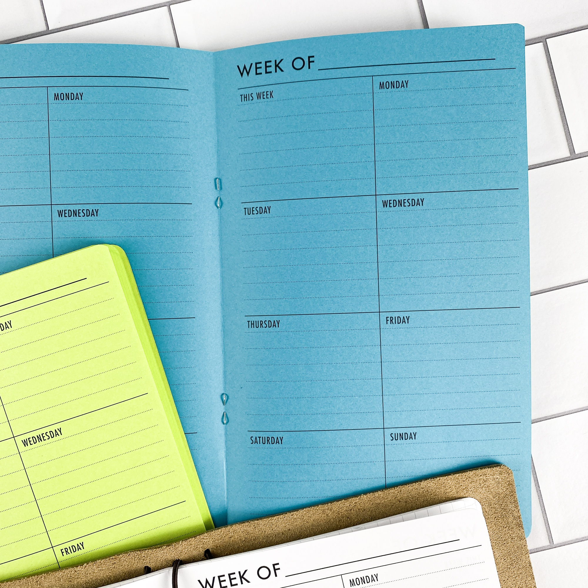 Close-up detail of the Week on 1 Page Vertical traveler's notebook refill showing the page layout and vertical weekly planner layout fitting a full week on one page in colored paper.
