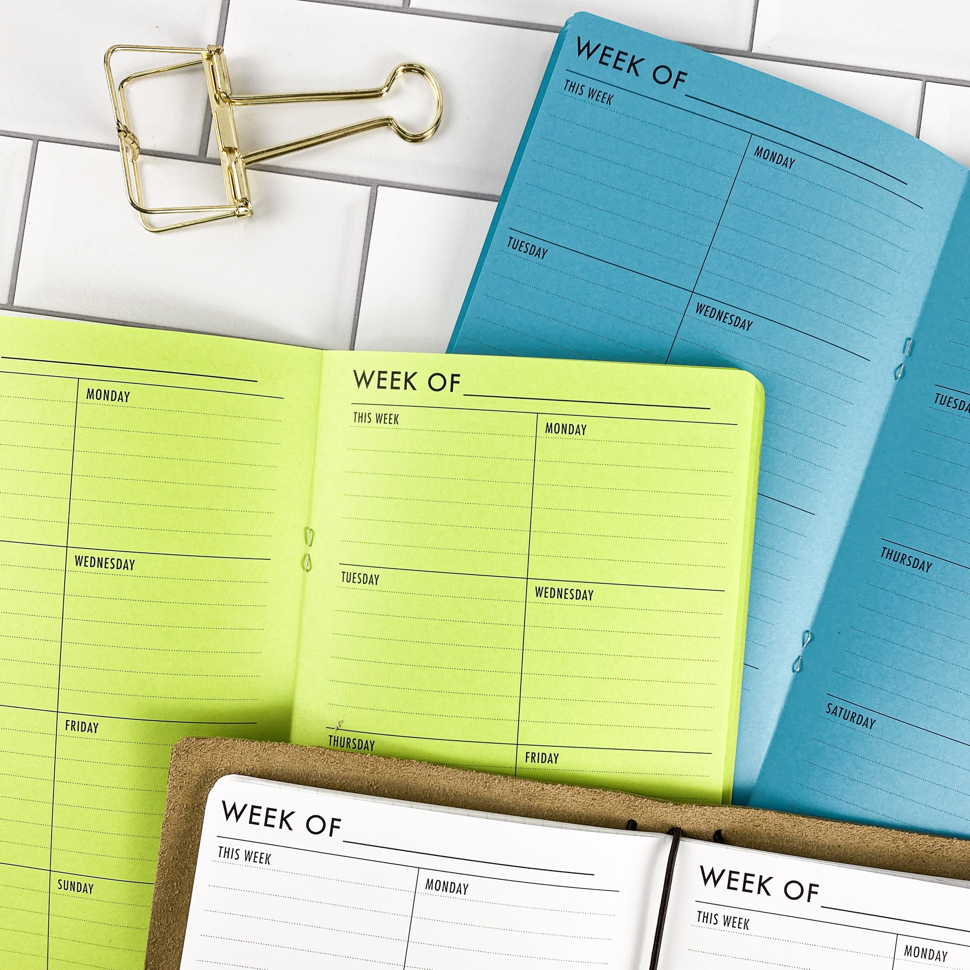 Detail view of the Week on 1 Page Vertical traveler's notebook refill showing vertical weekly planner layout fitting a full week on one page, displayed with multiple paper color options.