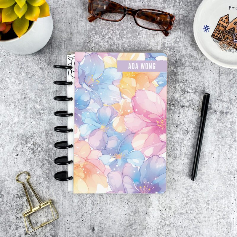 Personalized disc bound password book in pastel floral pattern with laminated cover, black discs, and custom name
