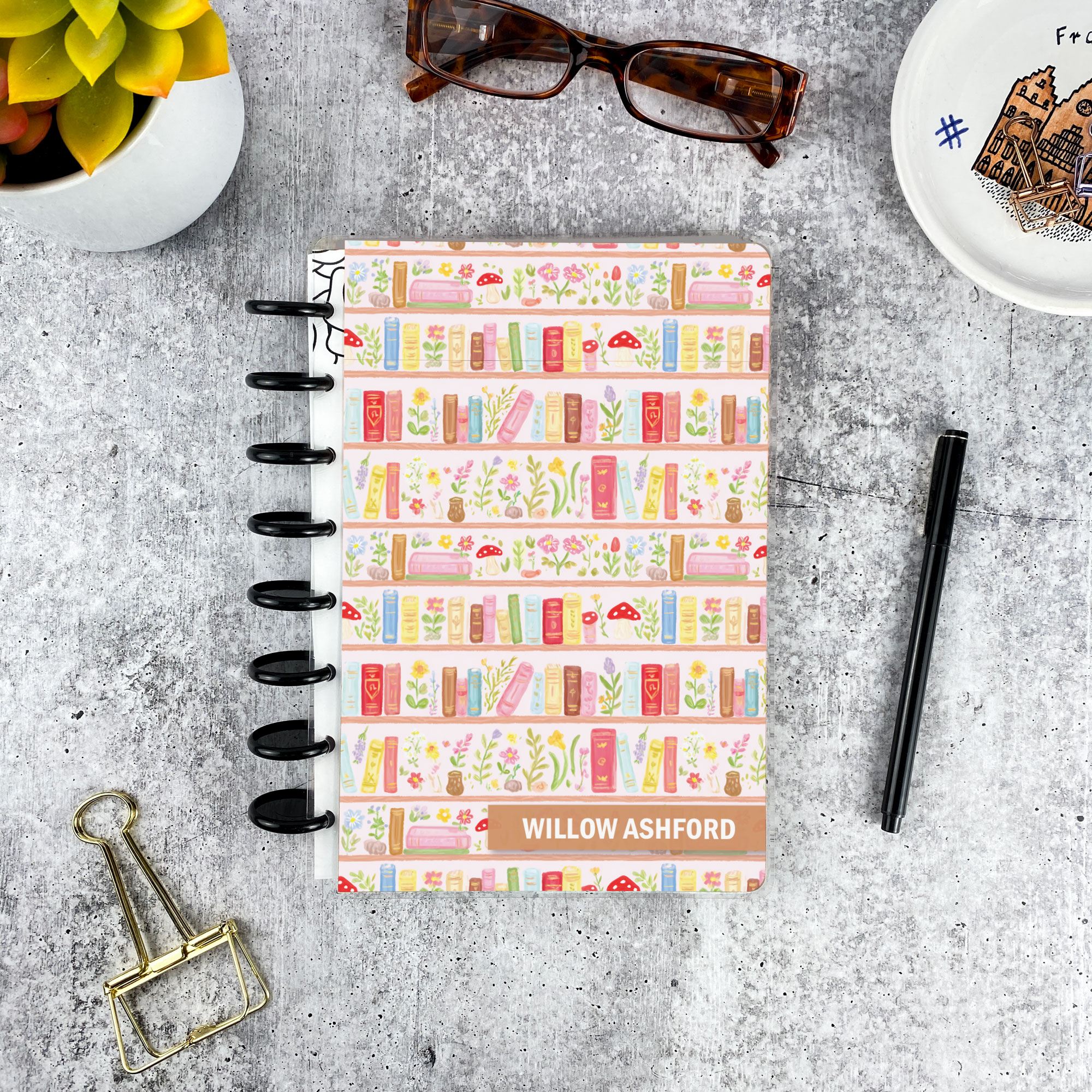 Personalized disc bound password book in pastel book shelf pattern with laminated cover, black discs, and custom name